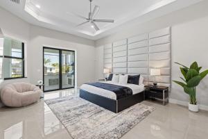 a bedroom with a bed and a ceiling fan at Modern Luxury Oasis Pool and Dock in Cape Coral +36 photos