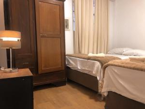 een kamer met 2 bedden, een kast en een lamp bij Mini departamento con cochera in Ayacucho