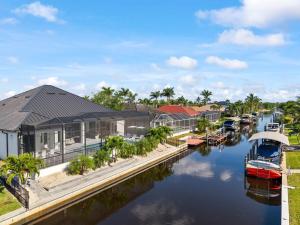 a house on the water with boats in a canal at Modern Luxury Oasis Pool and Dock in Cape Coral