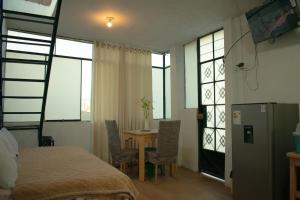 een slaapkamer met een bed en een tafel en een aantal ramen bij Mini departamento con cochera in Ayacucho