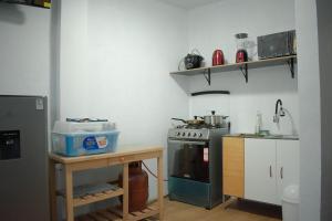 een keuken met een fornuis en een tafel erin bij Mini departamento con cochera in Ayacucho +6 foto's