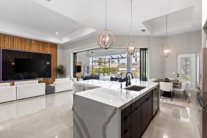 a kitchen and living room with a sink and a tv at Modern Luxury Oasis Pool and Dock in Cape Coral