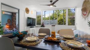 a dining room with a table with food on it at Escale Marine à deux pas des plages et de la Marina in Les Trois-Îlets