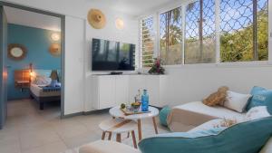 a living room with a couch and a table at Escale Marine à deux pas des plages et de la Marina in Les Trois-Îlets