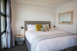 a bedroom with a large bed with yellow pillows at Hello QT Lakeside Gem in Queenstown