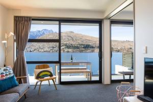 a living room with a view of the water at Hello QT Lakeside Gem in Queenstown