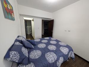 een slaapkamer met een bed met een blauw en wit dekbed bij Casa Milos in Guatemala