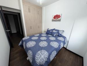 een slaapkamer met een blauw en wit bed met blauwe kussens bij Casa Milos in Guatemala