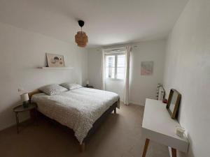 een witte slaapkamer met een bed en een raam bij Chill' Appart Disneyland in Chessy