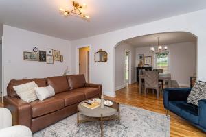 ein Wohnzimmer mit einem braunen Sofa und einem Tisch in der Unterkunft 3 bed 2 bath-Walk to Jack Trice Stadium in Ames