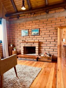 a living room with a brick wall with a fireplace at Maria Rita dos Canyons in Praia Grande