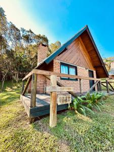 a log cabin with a porch in front of it at Maria Rita dos Canyons in Praia Grande
