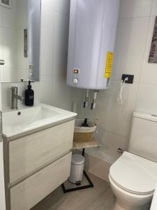een badkamer met een witte wastafel en een toilet bij Puerto Montt Centro - Diagonal Germania in Puerto Montt