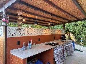 an outdoor kitchen with a counter top under awning at Chácara Adelly in Piaçabuçu