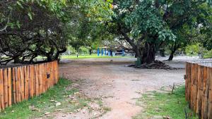 a wooden fence and a tree in a park at Chácara Adelly in Piaçabuçu +61 photos