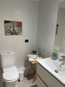een witte badkamer met een toilet en een wastafel bij Puerto Montt Centro - Diagonal Germania in Puerto Montt