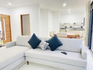 ein weißes Sofa mit blauen Kissen in einem Wohnzimmer in der Unterkunft JiuteHaus 7 in Jiutepec