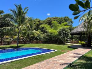 a swimming pool in a yard with palm trees at Chácara Adelly in Piaçabuçu