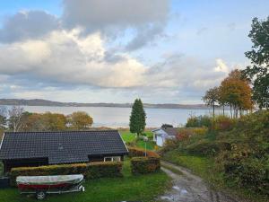 ein Haus mit einem Boot auf dem Hof in der Unterkunft Family-Friendly Cottage Near the Coast in Tirsbæk