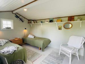 a room with two beds and a chair in it at 2 person holiday home in RAMDALA in Trummenas