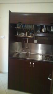 a kitchen with a stainless steel sink and shelves at Bella Vista Apartments in Nea Vrasna