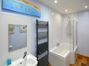 a bathroom with a shower and a tub and a sink at Uplands in Dalbeattie