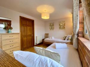 a living room with two beds and a dresser at Dabinett in Ledbury