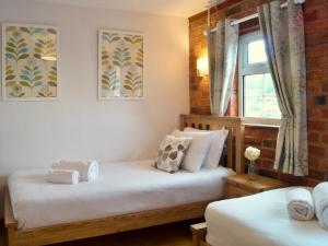 a bedroom with two beds and a window at Dabinett in Ledbury