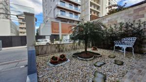 a bench and a tree on the side of a street at Apartamento 3 quartos prox passeio Pedra Branca in Palhoça