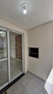 an empty room with a glass door and a window at Apartamento 3 quartos prox passeio Pedra Branca in Palhoça