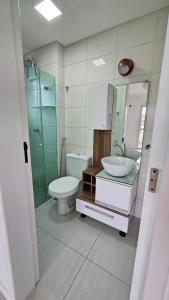 a bathroom with a toilet and a sink and a shower at Apartamento 3 quartos prox passeio Pedra Branca in Palhoça