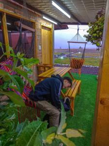 een man die in een hangmat op een veranda slaapt bij Sigchos Lodge in Sigchos +2 foto's