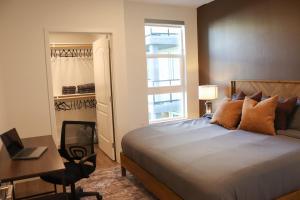 a bedroom with a bed and a desk and a window at Resort-Style APT with Pool, Gym & Parking 10min to Disneyland in Tustin +80 photos