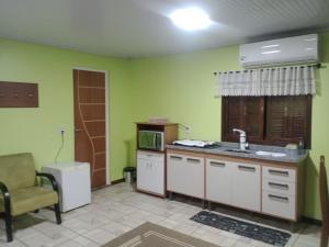 a kitchen with a sink and a microwave at Refúgio familiar in Canela
