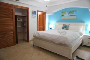 a bedroom with a large bed with a blue wall at Tranquil Oceanside: Pools & Direct Beach Access in Lowlands +44 photos