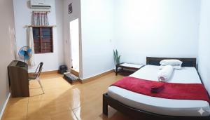 a bedroom with a large bed with a red blanket at Labore Homestay in Waha