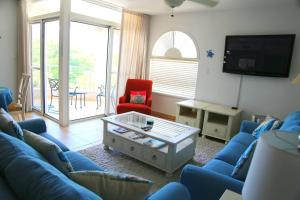 a living room with a blue couch and a red chair at Tranquil Oceanside: Pools & Direct Beach Access in Lowlands