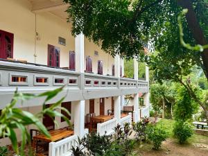 a building with white columns and red windows at Nong Khiaw Meexai Sunset View in Nongkhiaw
