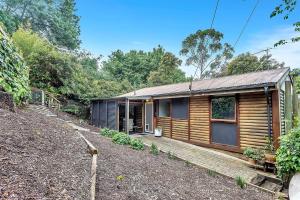 eine Holzhütte im Wald mit Hof in der Unterkunft Treetop Sanctuary - Serene Cottage near Mount Lofty in Upper Sturt