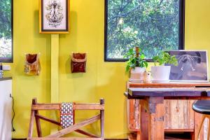 eine gelbe Wand mit einem Holztisch und einem Stuhl in der Unterkunft Treetop Sanctuary - Serene Cottage near Mount Lofty in Upper Sturt