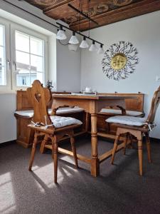 a dining room with a wooden table and two chairs at Haus Am See Mühlruh in Horn