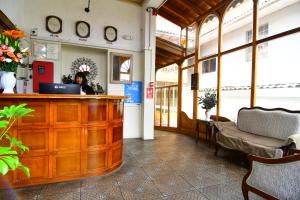 a woman sitting at a counter in a room with a laptop at Centenario Inn in Cusco