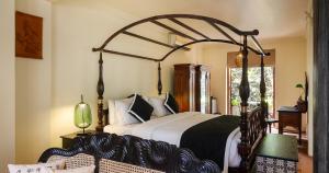 a bedroom with a large bed with a wooden canopy at Villa 98 in Malabe +36 photos