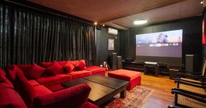 a living room with a red couch and a screen at Villa 98 in Malabe