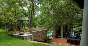 a garden with a vase on a stone wall at Villa 98 in Malabe