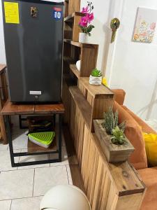 a living room with a tv on a wooden wall at El Jardín de Tere in Bijagua