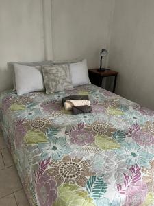 a bed with a colorful blanket on top of it at El Jardín de Tere in Bijagua