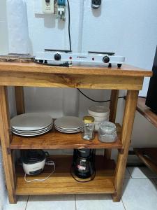 a wooden shelf with plates and dishes on it at El Jardín de Tere in Bijagua +12 photos