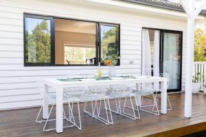 a white dining table and chairs on a porch at Oaklight Haven - Minutes to Geelong Waterfront & CBD in Hamlyn Heights