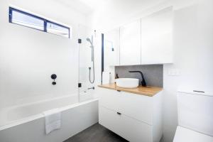 a white bathroom with a sink and a shower at Oaklight Haven - Minutes to Geelong Waterfront & CBD in Hamlyn Heights +25 photos